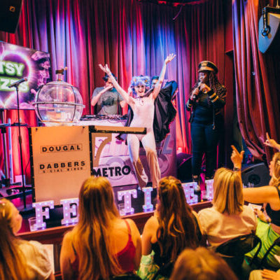 Vibrant event scene with performers on stage and an engaged audience enjoying a lively performance.