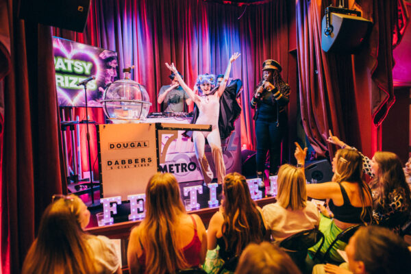 Vibrant event scene with performers on stage and an engaged audience enjoying a lively performance.